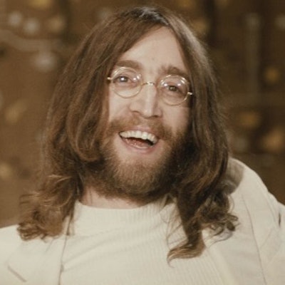 John Lennon with long locks and facial hair.