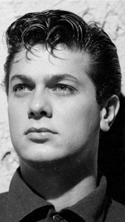 Tony Curtis wearing a duck tail hairstyle.