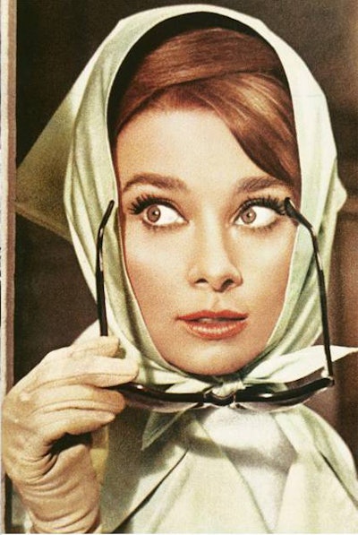 Audrey Hepburn sports a hair scarf and sunglasses.