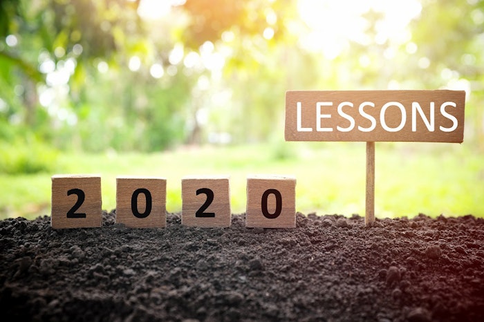 Life lessons and learnings from the year 2020 concept. A tree branch with a single remaining last leaf hanging beside a 2020 learning in wooden blocks at sunset.