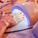 Client cures gel nails in UV light