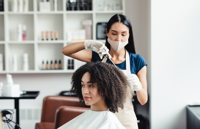 Hair dresser cutting textured hair