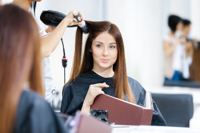 Beautician doing a blowout on a female client