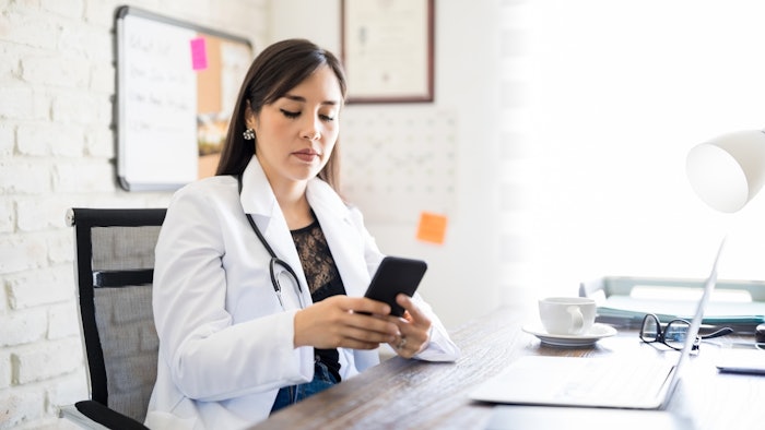 female doctor using phone posting on social media