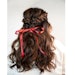 See how to achieve Karla Valenzuela's half-up, half-down twisted braid.