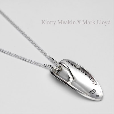The back of the pendant is inscribed with the brand name