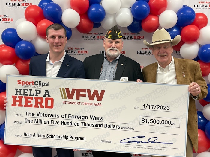 Veterans hold $1.5 million check from Sport Clips Haircuts.