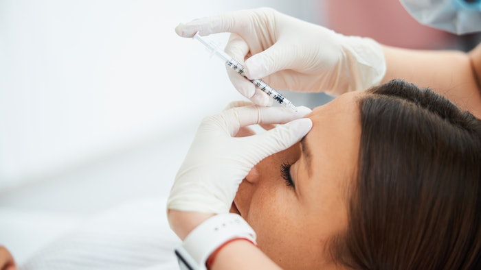 woman receiving filler injection in glabellar lines