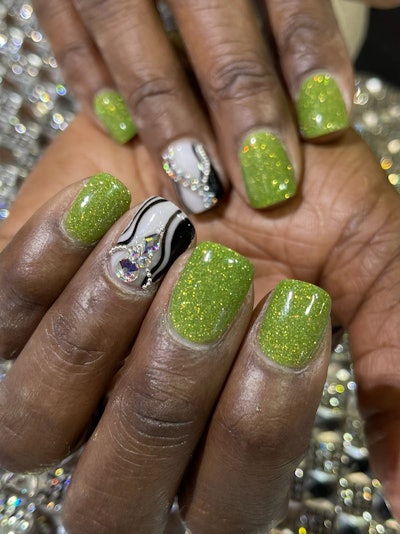 Nailpro Business Development Manager Shamella Anderson shows off her nail gems applied by Tino Vo at the Dreamtime Creations booth at ABS 2023.