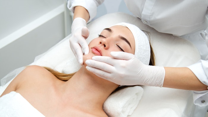 Woman getting face beauty treatment in medical spa center.