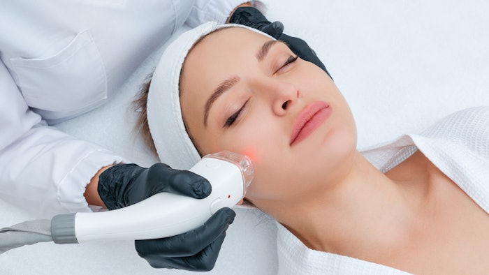 Young woman receiving laser treatment in cosmetology clinic