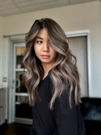 Jada Santi's client rocking a balayage while looking over her shoulder.