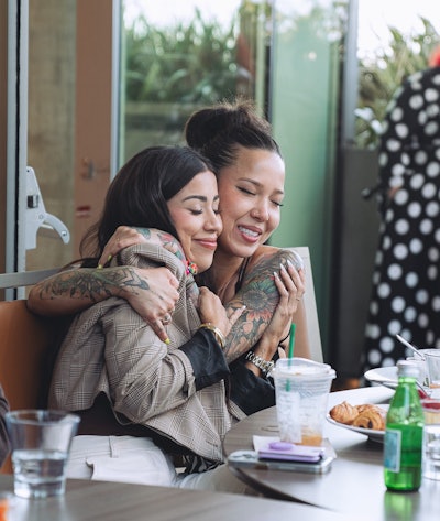 Kat Summers and Maggie Hancock embracing at Olaplex Pro Collective event celebrating 10 years of Olaplex.