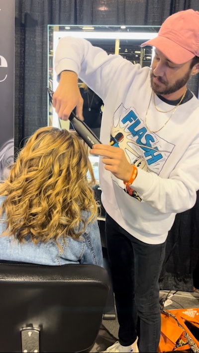 Drew Noreen styling Associate Managing Editor Gabby Bach's hair with the Nicky Clarke InfraRed PRO Titanium Straightener at America's Beauty Show 2024.