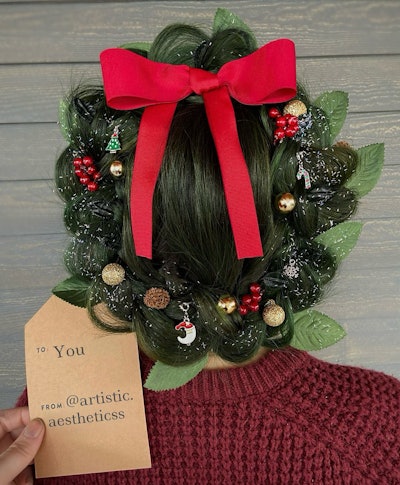 Forrest Green colored hair braided into a wreath with charms, holly and a red bow.