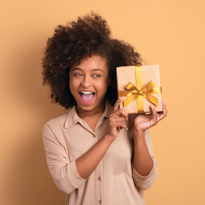 Woman holding a present wrapped with a bow.