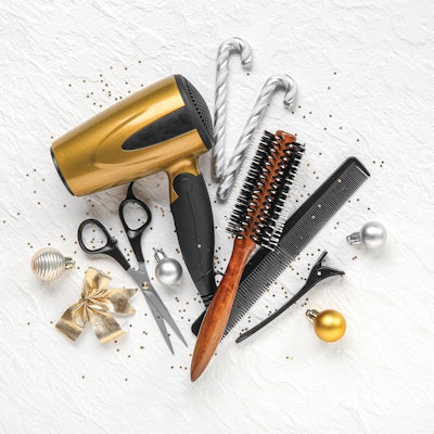 Composition with hairdresser's supplies and Christmas decorations on light background