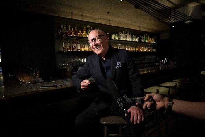 Trevor Sorbie sits for an interview at a bar with a smile on his face.