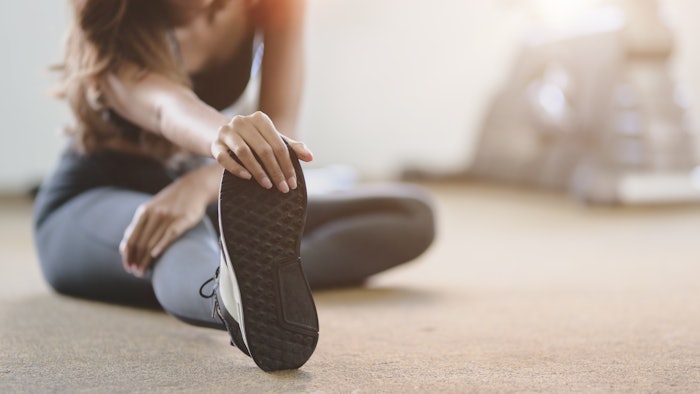 Person stretching by reaching for their foot.