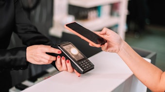 Person paying for beauty services using their smartphone.