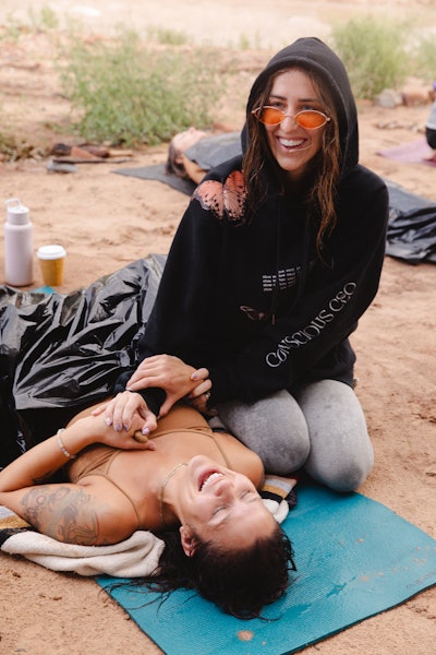 Elizabeth Faye with an attendee at one of her retreats, helping her practice meditation/breathwork.