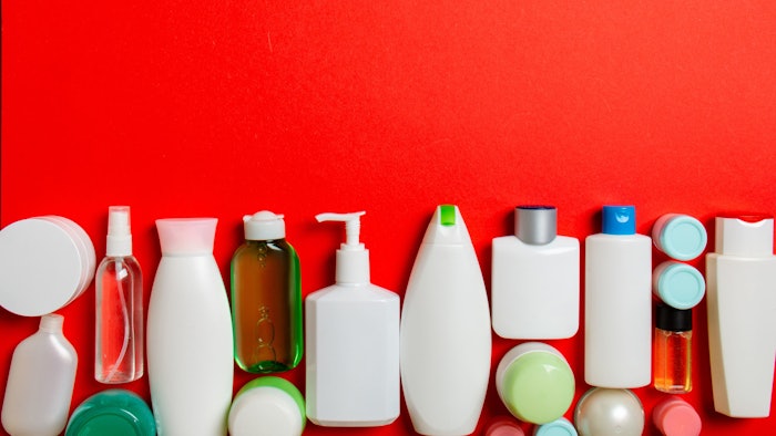 mix of personal care product bottles laying on red background