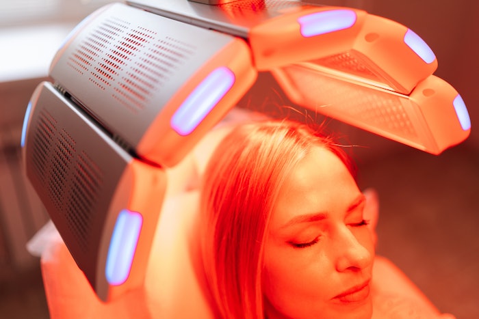 Woman receiving red light therapy treatment.