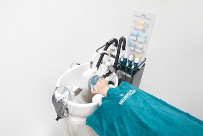 Overhead shot of K-Headspa shampoo bowl, showerhead and skincare bed with sparkling tablet display case.