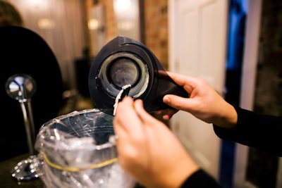 Hairstylist recycling color out of a container.