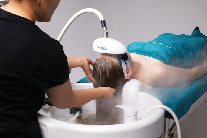 Client receiving a head spa service using K-Headspa's showerhead