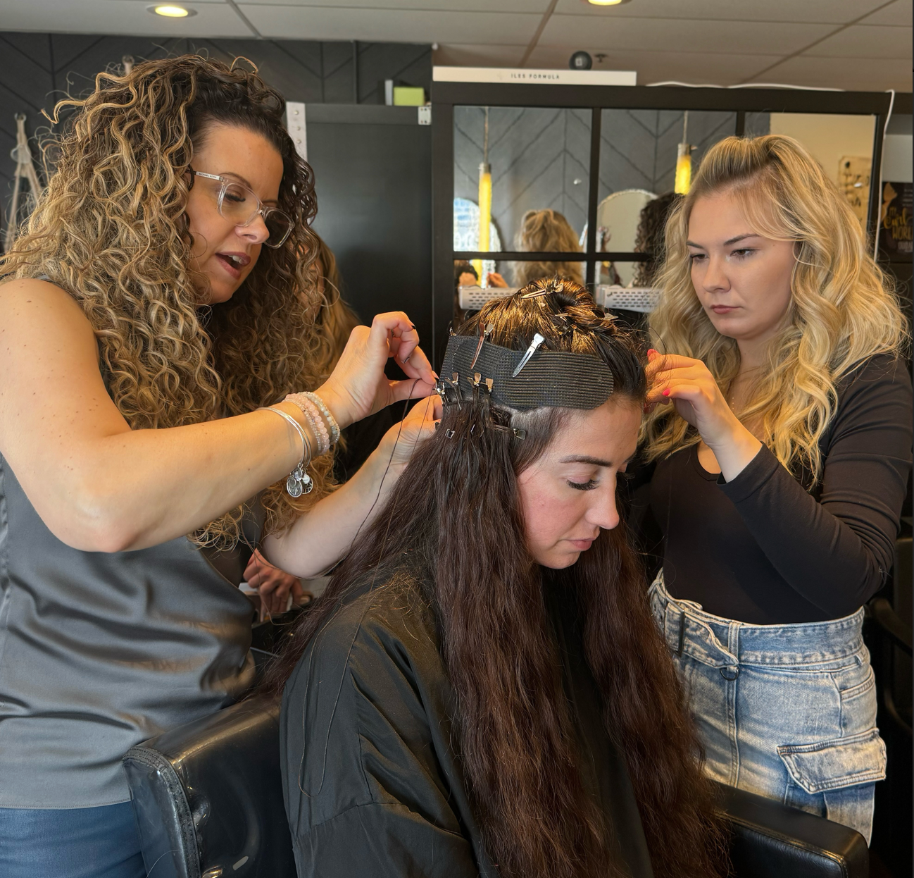 Jennifer Janisch and Chloe Hartnett installing Adored Hair Extensions on a client.