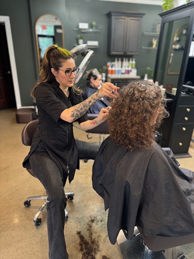 Tracey giving a client a haircut in her salon.