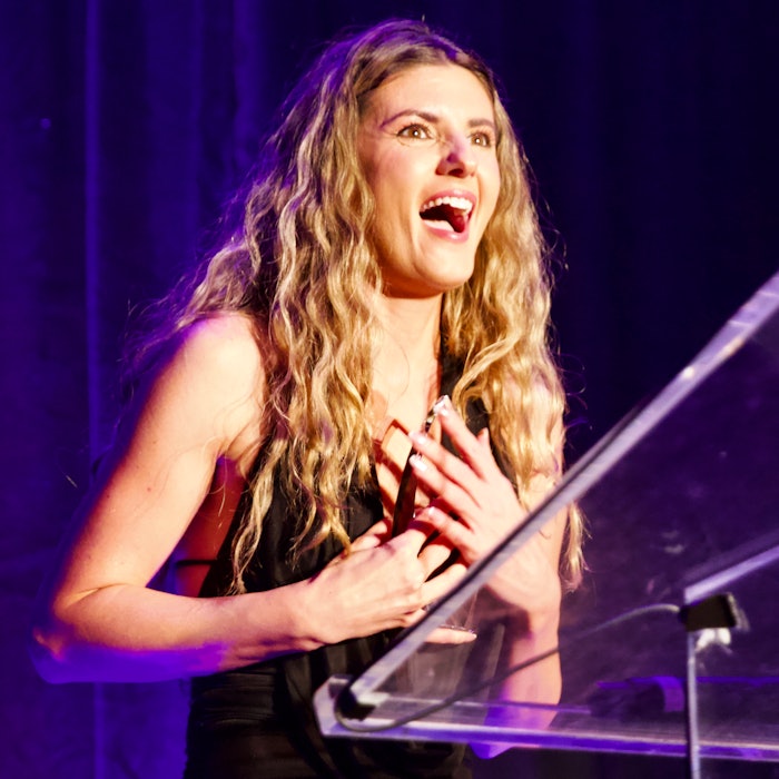 Nina winning an award at the Beyond the Ponytail Styling Awards.