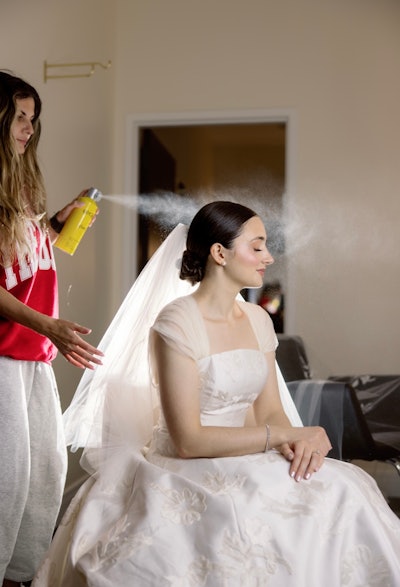 Nina finishing one of her bride's hair with hairspray.