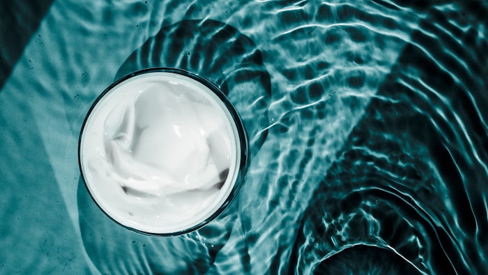 skin care cream in a jar with watery background