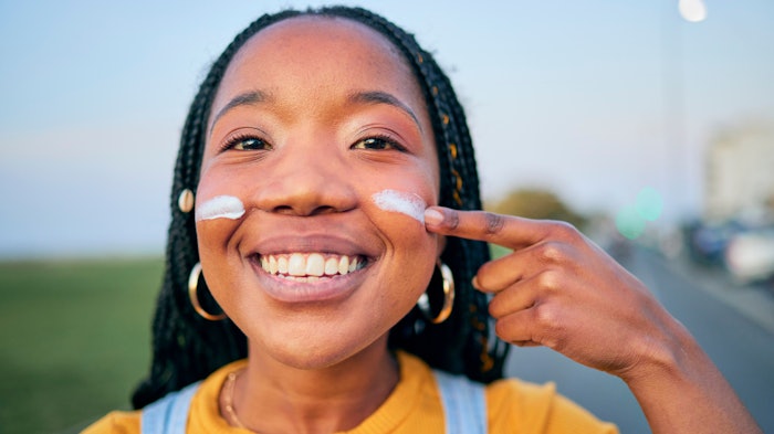 Young Black Woman Outside Applying Sunscreen To Cheeks Adobe Stock 672065582 (1)