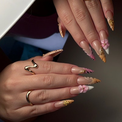 3D floral nail art with cross charms and animal print nail French tips