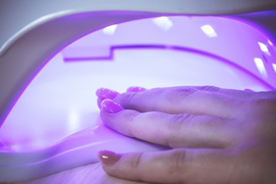 Nails curing in a UV lamp