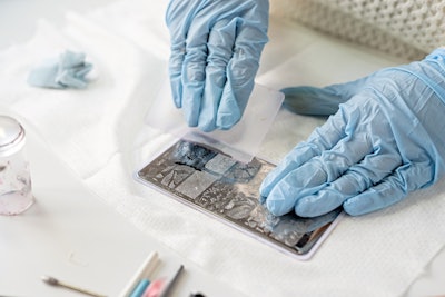 Nail tech using a nail stamp plate