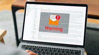 Hand using laptop with shows a warning screen of new email notifications