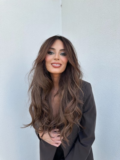 Brunette with long, wavy hair and curtain bangs