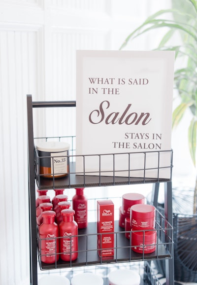 What is said in the salon stays in the salon sign with Wella Ultimate Repair collection products on a cart