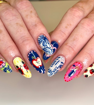 Abstract nail art that features lady bugs, apples, a person blowdrying their hair and more
