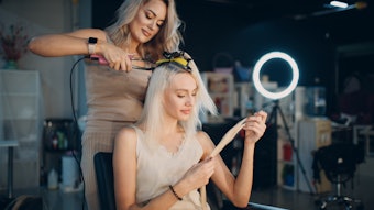 Hairstylist applying hair extensions to a client.