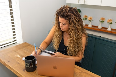 Jennifer working on her computer, managing her extension business.