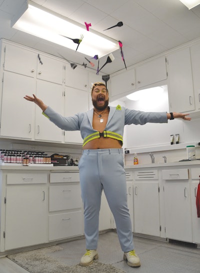 Willy throws hair tools into the air in the back room of his salon.