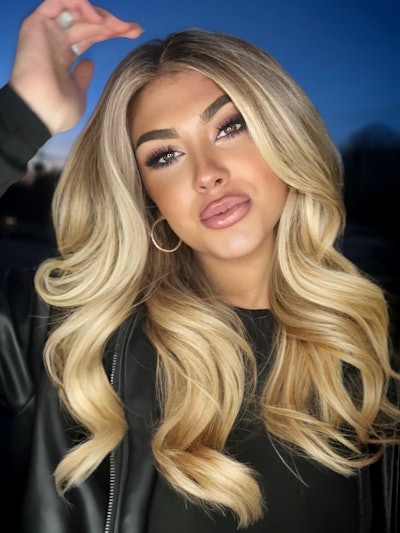 A golden, wavy blonde TREND Model that is posing for the camera.