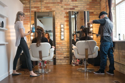 Stylists working on their individual clients in a salon space.