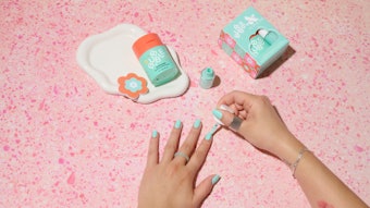 Bubble x Olive & June collection. A model paints her nails with a teal polish.