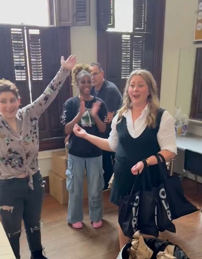 Gabby and volunteers celebrate stuffing over 300 swag bags filled with Olaplex products.